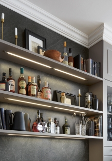 Vizuální dominantu tvoří otevřené osvětlené police Šedá kuchyně Schüller Classic